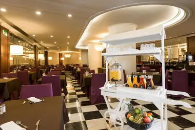 a restaurant with a checkered floor and purple chairs at Hotel Barcelona Center in Barcelona