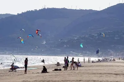 a group of people on a beach flying kites at Sunset Boutique Castelldefels by MyRentalHost in Castelldefels