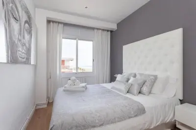 a bedroom with a large bed with a large window at Sunset Boutique Castelldefels by MyRentalHost in Castelldefels