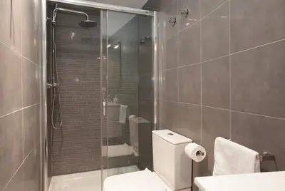 a bathroom with a toilet and a glass shower at Habitat Apartments Alissia in Barcelona