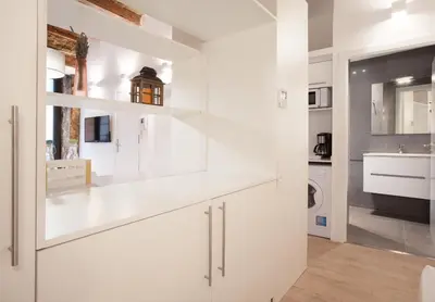 a kitchen with white cabinets and a sink at Habitat Apartments Alissia in Barcelona