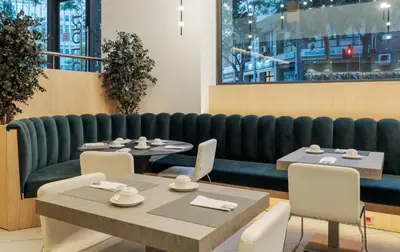 a restaurant with tables and chairs and a kitchen at Ilunion Auditori in Barcelona