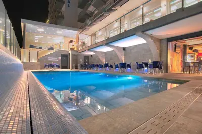 a large swimming pool with blue water in a building at Hotel Internacional in Calella