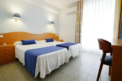 a bedroom with a large bed and a large window at Hotel Internacional in Calella