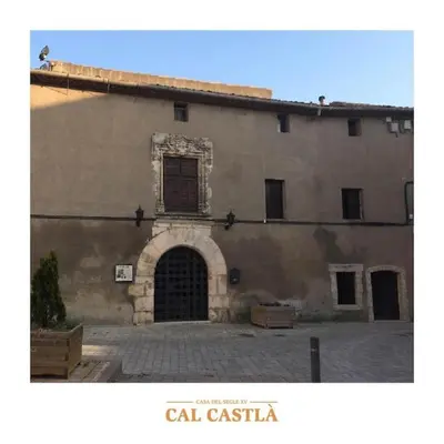 a large stone building with a door and an archway at Cal Castlà in La Granada