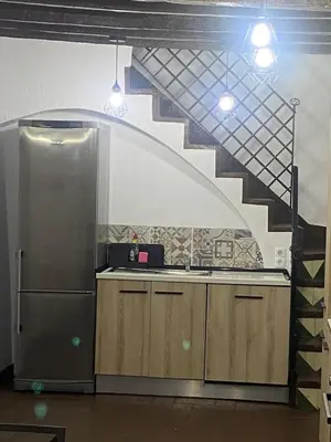 a kitchen with a sink and a staircase at Cal Castlà in La Granada