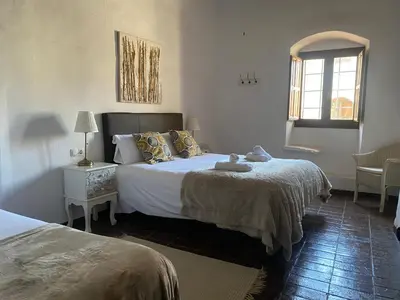 a bedroom with two beds and a window at Cal Castlà in La Granada