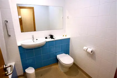 a bathroom with a sink and a toilet and a mirror at Travelodge Barcelona Fira in Hospitalet de Llobregat