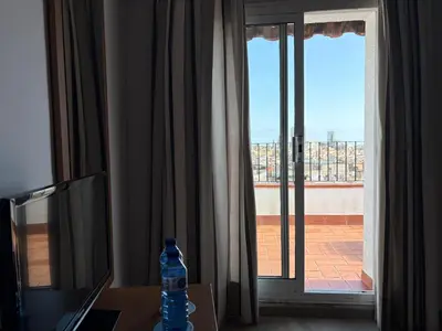 a bottle of water sitting on a table in front of a window at Ramblas Hotel in Barcelona