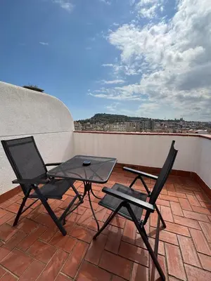 a patio with two chairs and a table on a roof at Ramblas Hotel in Barcelona