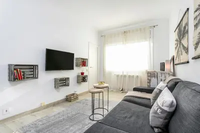 a living room with a couch and a tv on a wall at Click&Flat Rizal in Barcelona