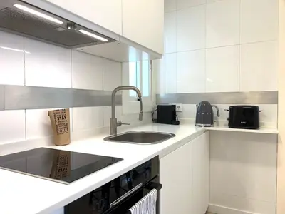 a kitchen with white cabinets and a sink and a sink at Click&Flat Rizal in Barcelona