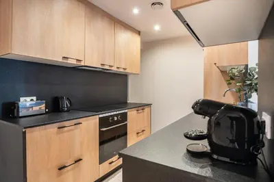 a kitchen with wooden cabinets and a black counter top at Design and comfort in the trendy neighborhood in Barcelona