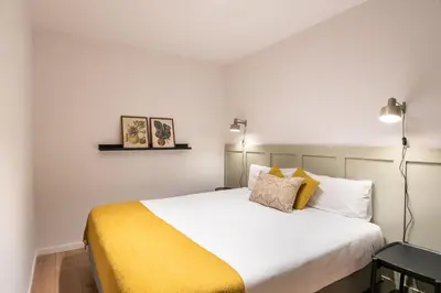 a bedroom with a large bed with a yellow blanket at Design and comfort in the trendy neighborhood in Barcelona