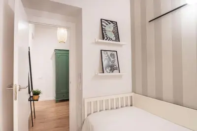 a room with a bed and a green door at Design and comfort in the trendy neighborhood in Barcelona