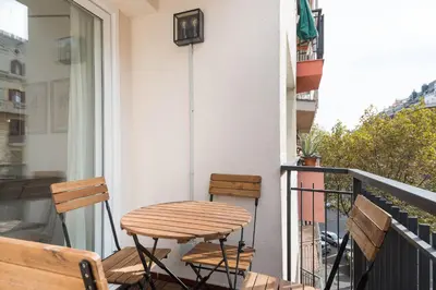 a wooden table and two chairs on a balcony at Style and design in the best location, Eixample Barcelona in Barcelona