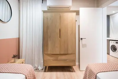 a room with two beds and a wooden cabinet at Style and design in the best location, Eixample Barcelona in Barcelona