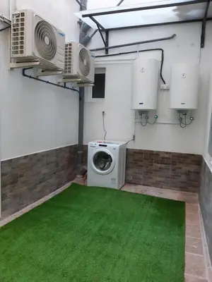 a laundry room with a washing machine and a green floor at Lucky House in Badalona
