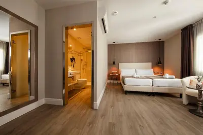 a bedroom with a white bed and a bathroom at Hotel Oasis in Barcelona