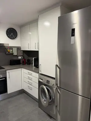 a kitchen with a refrigerator and a washing machine at La Llum de Sitges in Sitges