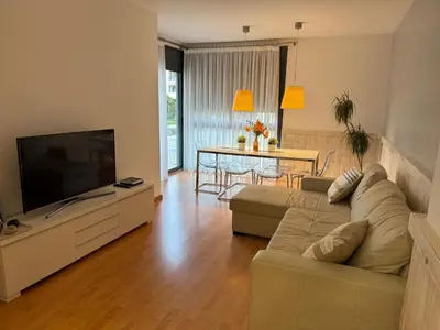 a living room with a couch and a flat screen tv at La Llum de Sitges in Sitges