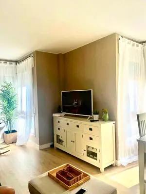 a living room with a television on a white dresser at Cardedeu City and Circuit apartment in Cardedeu