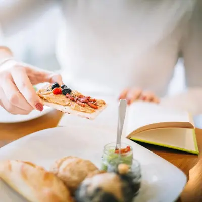 a person holding a slice of pizza on a plate at Petit Palace Boqueria Garden in Barcelona