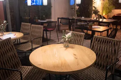 a wooden table with chairs and a vase of flowers on it at Petit Palace Boqueria Garden in Barcelona