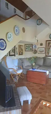 a living room with a couch and chairs and plates on the wall at Chalet Entre Parques Naturales in Vallgorguina