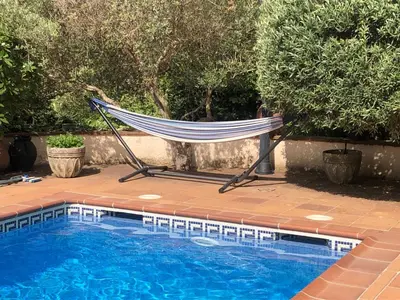 a hammock sitting next to a swimming pool at Chalet Entre Parques Naturales in Vallgorguina