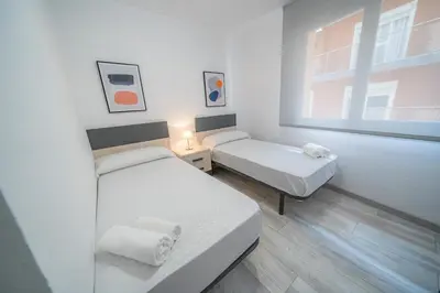 a small room with two beds and a window at HomeHolidaysRentals SantMartin - Costa Barcelona in Calella