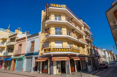 a tall yellow building with a sign on it at HomeHolidaysRentals SantMartin - Costa Barcelona in Calella