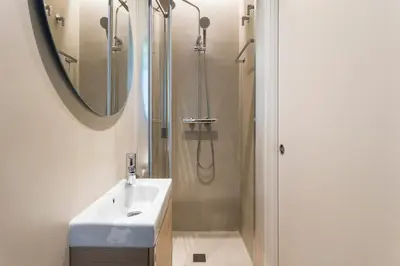 a bathroom with a sink and a shower with a mirror at Enjoy Apartments La Riera One in Barcelona