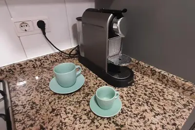two cups on a counter next to a coffee maker at Precioso Piso Barcelona in Santa Coloma de Cervelló