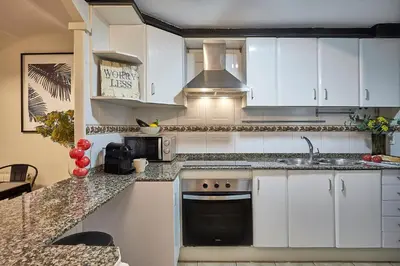 a kitchen with white cabinets and a sink at BBarcelona Parallel Apartment in Barcelona