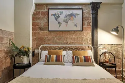 a bedroom with a bed with a brick wall at BBarcelona Parallel Apartment in Barcelona