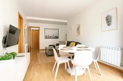 a white living room with a table and chairs at AB North Barcelona Apartments in Santa Coloma
