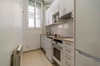 a kitchen with white cabinets and a sink and a window at AB North Barcelona Apartments in Santa Coloma