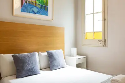 a bedroom with a bed with a wooden headboard and a window at Sagrada Familia III by Enjoy Apartments in Barcelona