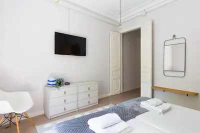 a white bedroom with a bed and a mirror at Sagrada Familia IV by Enjoy Apartments in Barcelona