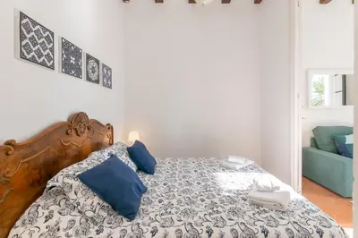 a bedroom with a bed with blue pillows at Vistamar 1: Primera línea de mar con encanto in Sitges