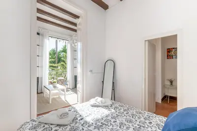 a white room with a bed and a mirror at Vistamar 1: Primera línea de mar con encanto in Sitges