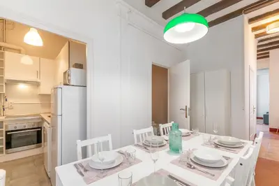 a kitchen and dining room with a white table and chairs at Vistamar 1: Primera línea de mar con encanto in Sitges