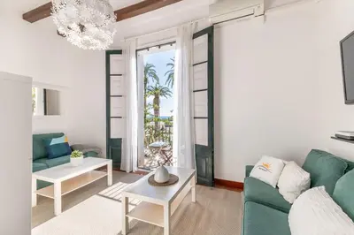 a living room with a green couch and a table at Vistamar 1: Primera línea de mar con encanto in Sitges