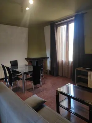 a living room with a table and a piano at Apartamentos Can bruguera 2 in Mataró