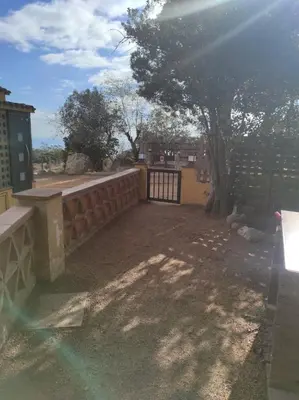 a backyard with a fence and a gate and a tree at Apartamentos Can bruguera 2 in Mataró