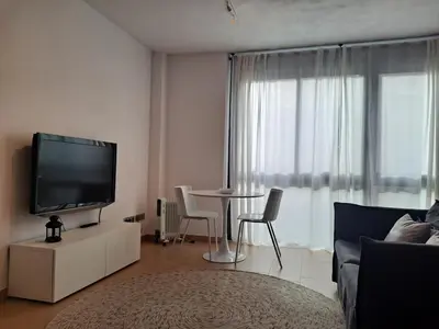 a living room with a tv and a table with chairs at Precioso loft al lado Parc Vallparadís by Lofties in Terrassa