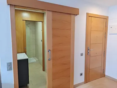a bathroom with a wooden door in a room at Precioso loft al lado Parc Vallparadís by Lofties in Terrassa
