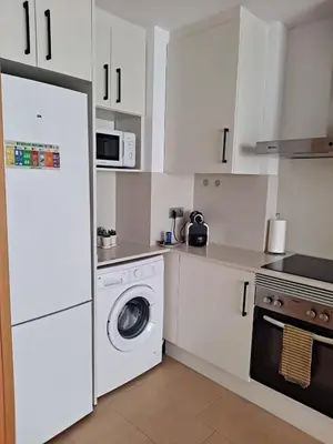 a white kitchen with a washing machine and a microwave at Precioso loft al lado Parc Vallparadís by Lofties in Terrassa