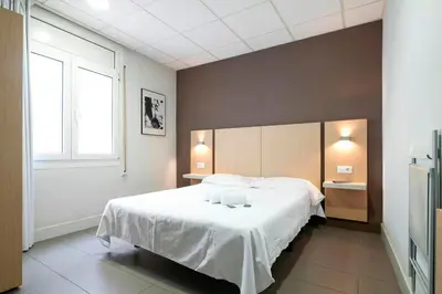 a bedroom with a large white bed and a window at Putxet by gaiarooms in Barcelona